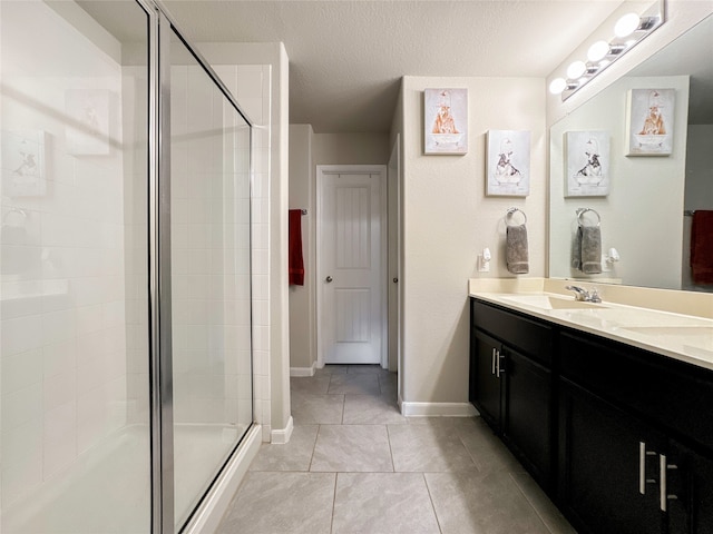 bathroom with vanity, tile patterned floors, a textured ceiling, and an enclosed shower