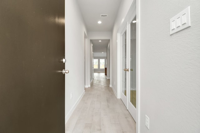 hallway featuring french doors and light hardwood / wood-style flooring