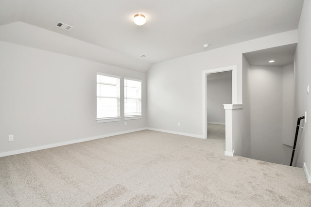 spare room with carpet and vaulted ceiling