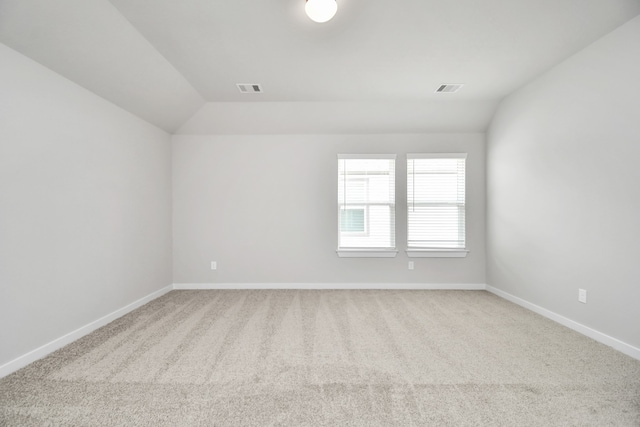 empty room with carpet flooring and vaulted ceiling