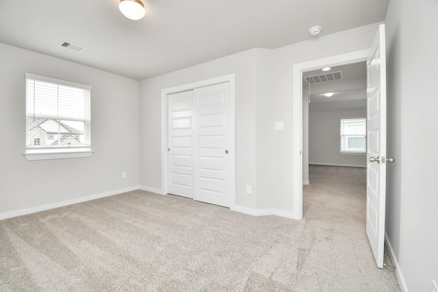 15714 Walnut Leaf Ln, Cypress, TX 77429 - unfurnished bedroom with light colored carpet, multiple windows, and a closet