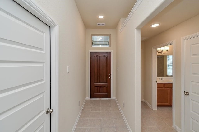 doorway featuring a notable chandelier and light tile patterned floors