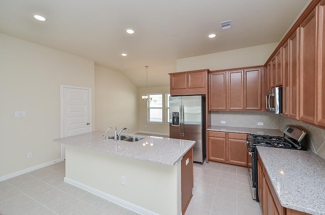 kitchen with light stone countertops, a kitchen island with sink, sink, and stainless steel appliances