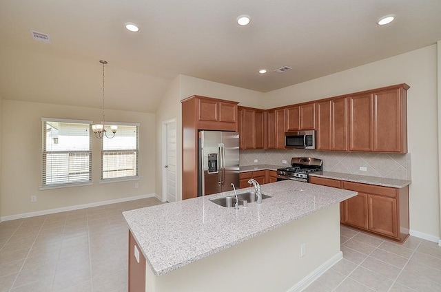 kitchen with stainless steel appliances, an inviting chandelier, a kitchen island with sink, and sink