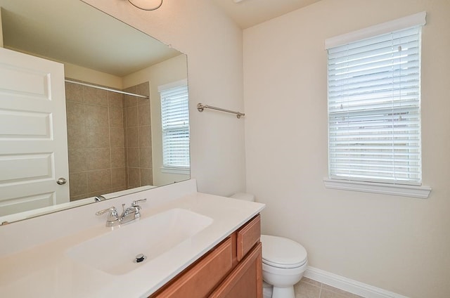 bathroom with tile patterned flooring, vanity, a healthy amount of sunlight, and toilet