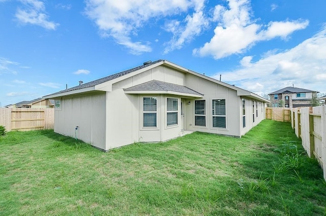 rear view of property with a lawn