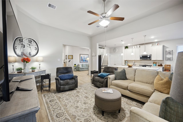 living room with light hardwood / wood-style floors and ceiling fan