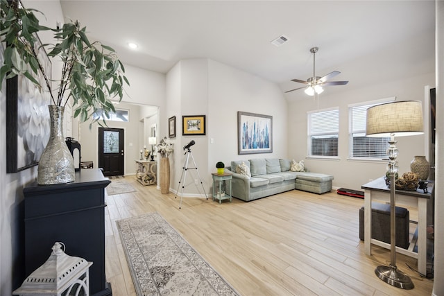 living room featuring light hardwood / wood-style floors, lofted ceiling, and ceiling fan