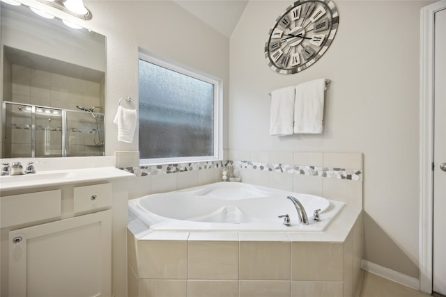 bathroom featuring vanity, vaulted ceiling, and shower with separate bathtub