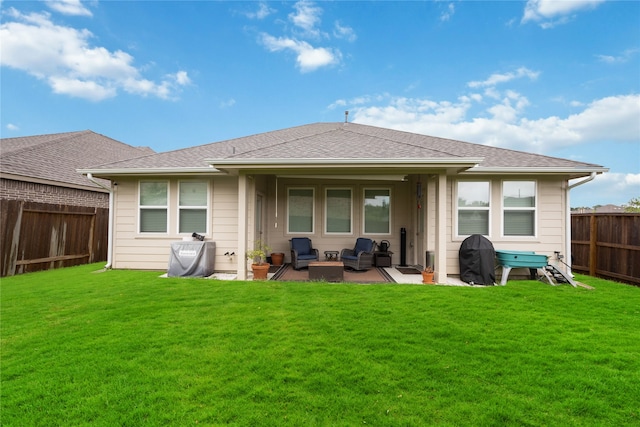 rear view of house with a yard and a patio