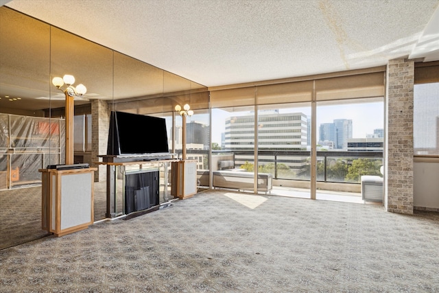 unfurnished living room featuring an inviting chandelier, a textured ceiling, and carpet