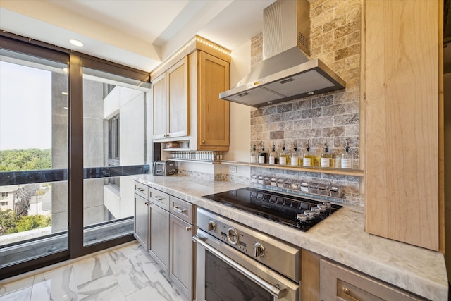 kitchen with black electric stovetop, light brown cabinets, stainless steel oven, wall chimney exhaust hood, and tasteful backsplash