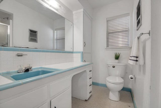 bathroom with vanity, toilet, and backsplash