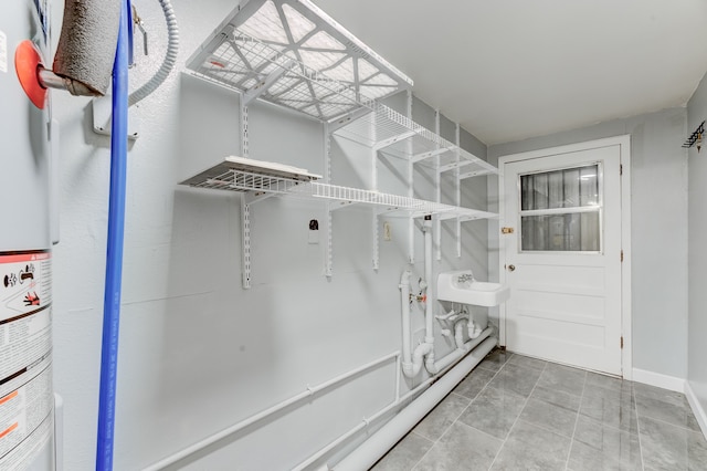 interior space featuring water heater, sink, and tile patterned flooring