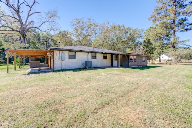 rear view of house with central AC, a lawn, and a carport