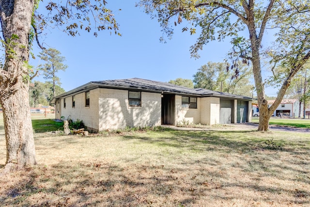 single story home featuring a front yard and a garage