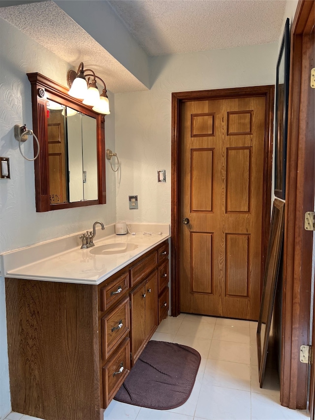 bathroom with vanity, a textured ceiling, and tile patterned flooring