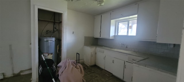 kitchen with white cabinetry, decorative backsplash, sink, and water heater