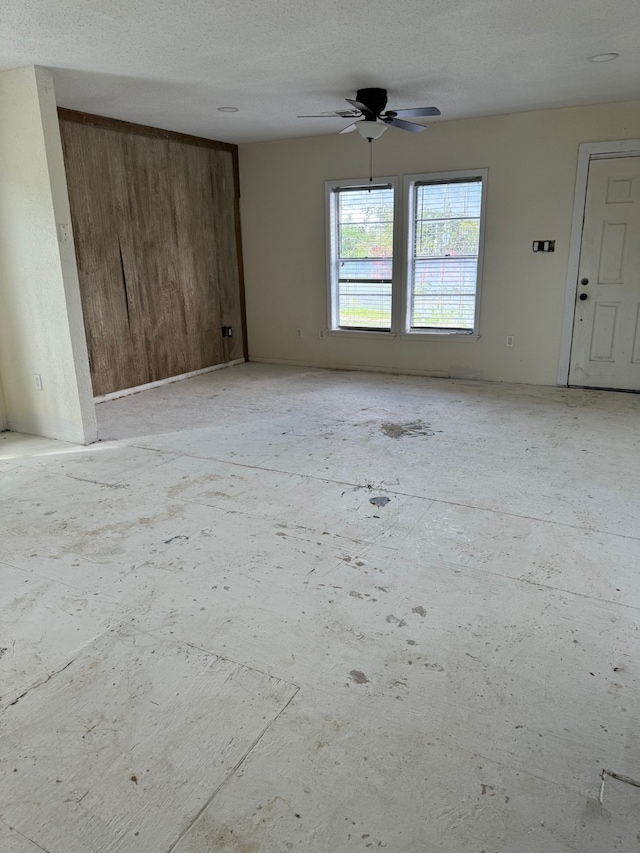 empty room featuring a textured ceiling and ceiling fan