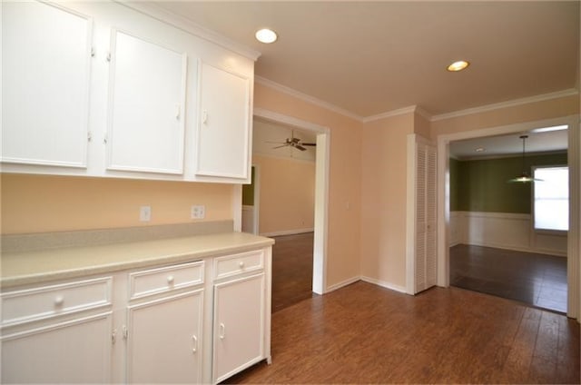 kitchen with ornamental molding, white cabinetry, dark wood-type flooring, and ceiling fan