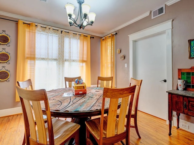 dining space with an inviting chandelier, crown molding, and light wood-type flooring