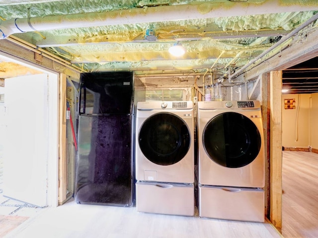 clothes washing area featuring hardwood / wood-style flooring and separate washer and dryer