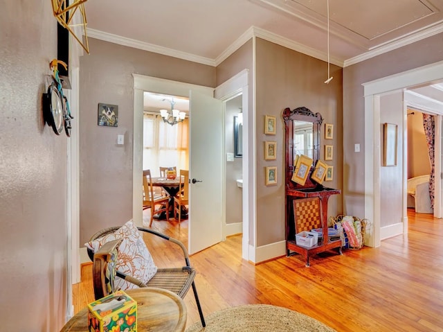 hall featuring a chandelier, crown molding, and light wood-type flooring