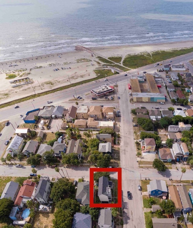 birds eye view of property featuring a water view and a beach view