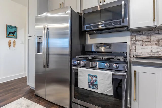 kitchen featuring decorative backsplash, appliances with stainless steel finishes, white cabinets, and dark hardwood / wood-style flooring