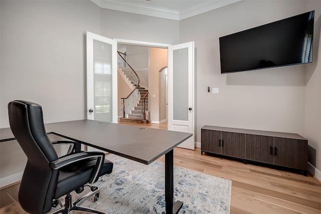 office space featuring french doors, light hardwood / wood-style floors, and crown molding