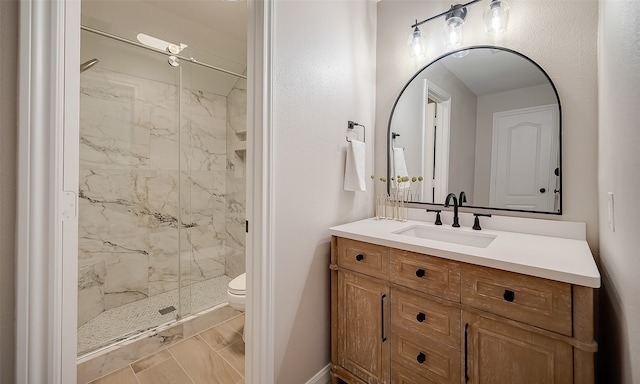 bathroom with vanity, toilet, and a shower with door