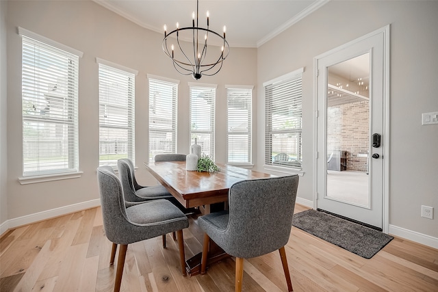 dining space with a notable chandelier, ornamental molding, and light wood-type flooring