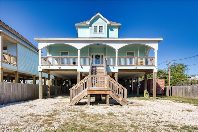 view of front of home with a porch, dirt driveway, stairs, and a carport