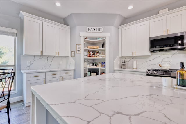 kitchen featuring white cabinetry, appliances with stainless steel finishes, and wood-type flooring