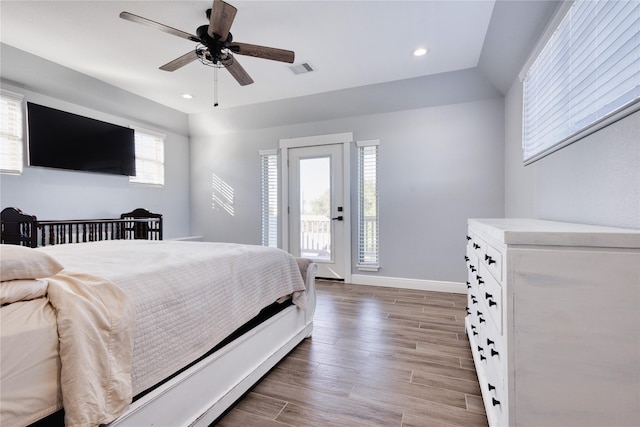 bedroom featuring visible vents, access to exterior, wood finished floors, and multiple windows