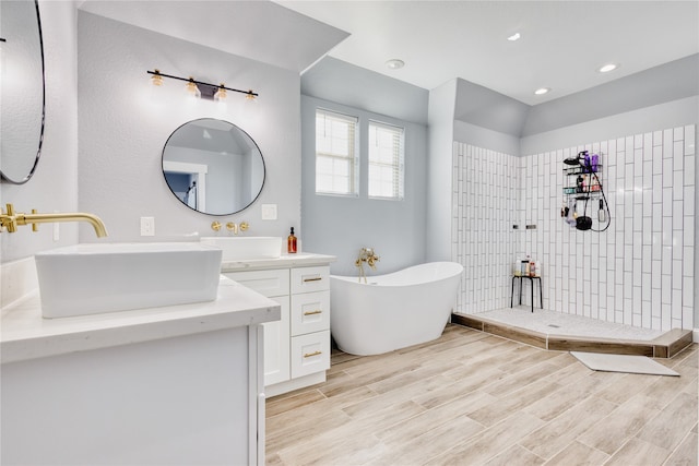 bathroom with vanity, wood-type flooring, and plus walk in shower