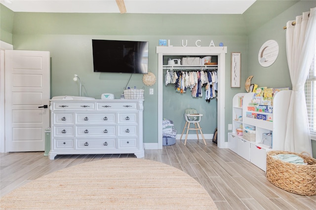 bedroom with a closet, wood tiled floor, and baseboards