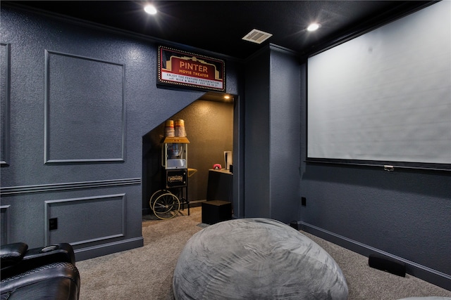 cinema room featuring ornamental molding and carpet flooring