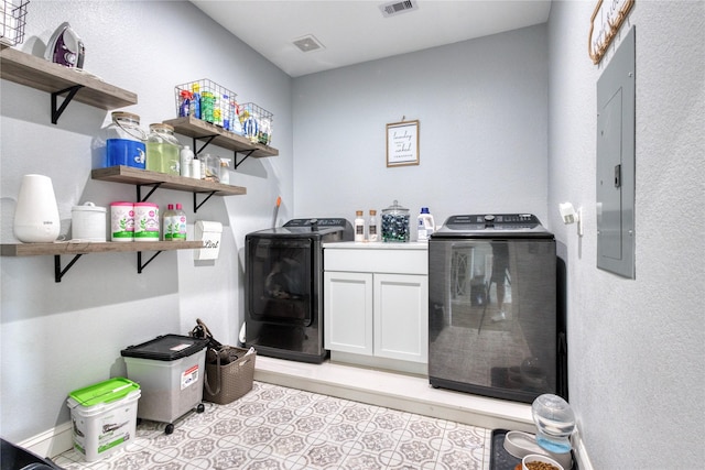 clothes washing area featuring visible vents, cabinet space, electric panel, and washing machine and clothes dryer