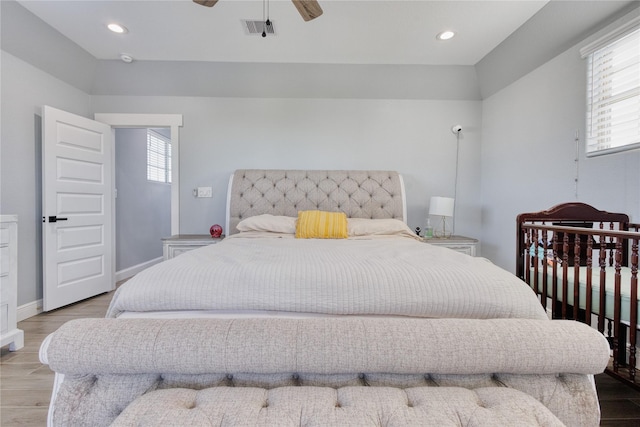 bedroom with baseboards, visible vents, multiple windows, and wood finished floors