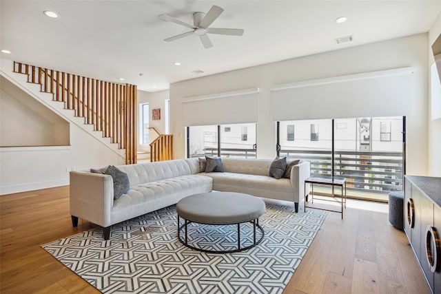 living room featuring wood-type flooring and ceiling fan