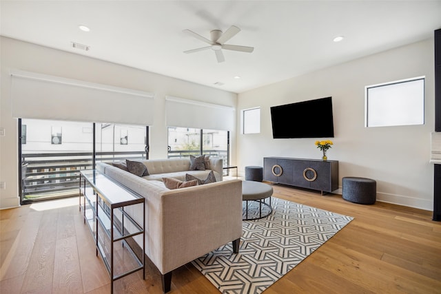 living room with ceiling fan and light hardwood / wood-style flooring