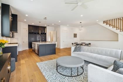 living room with light hardwood / wood-style floors and ceiling fan