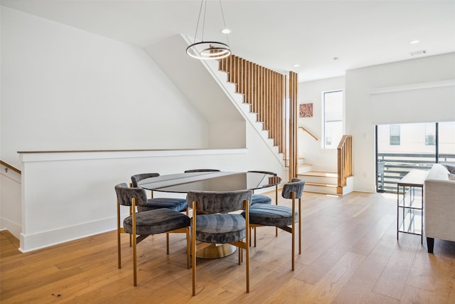 dining space with an inviting chandelier, plenty of natural light, and light wood-type flooring