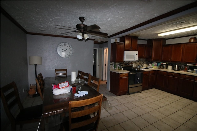 kitchen with light countertops, electric stove, a ceiling fan, light tile patterned floors, and white microwave