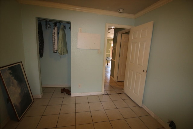 unfurnished bedroom featuring light tile patterned floors, baseboards, and ornamental molding
