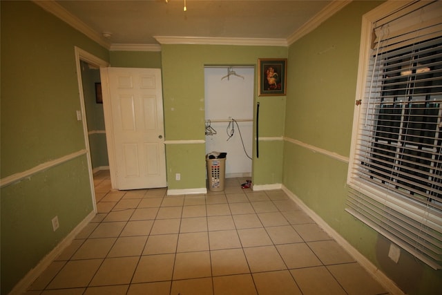 laundry area with ornamental molding and light tile patterned floors