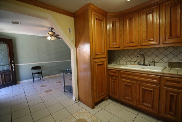 kitchen featuring tasteful backsplash, sink, ceiling fan, and light tile patterned floors