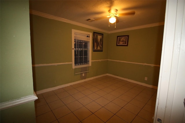 spare room featuring ceiling fan, ornamental molding, tile patterned floors, and visible vents