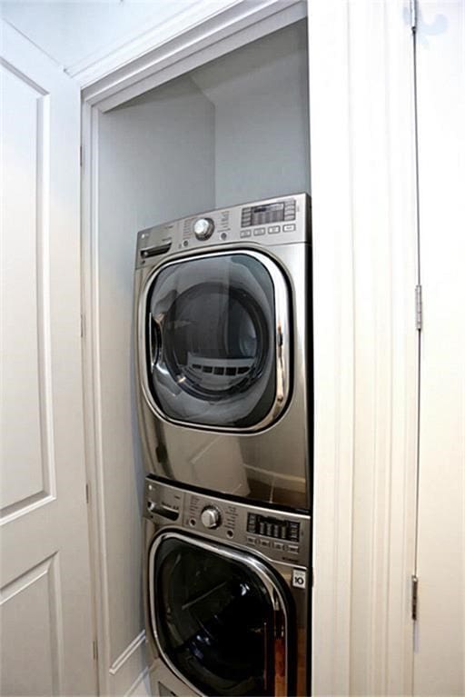 washroom featuring stacked washer / drying machine